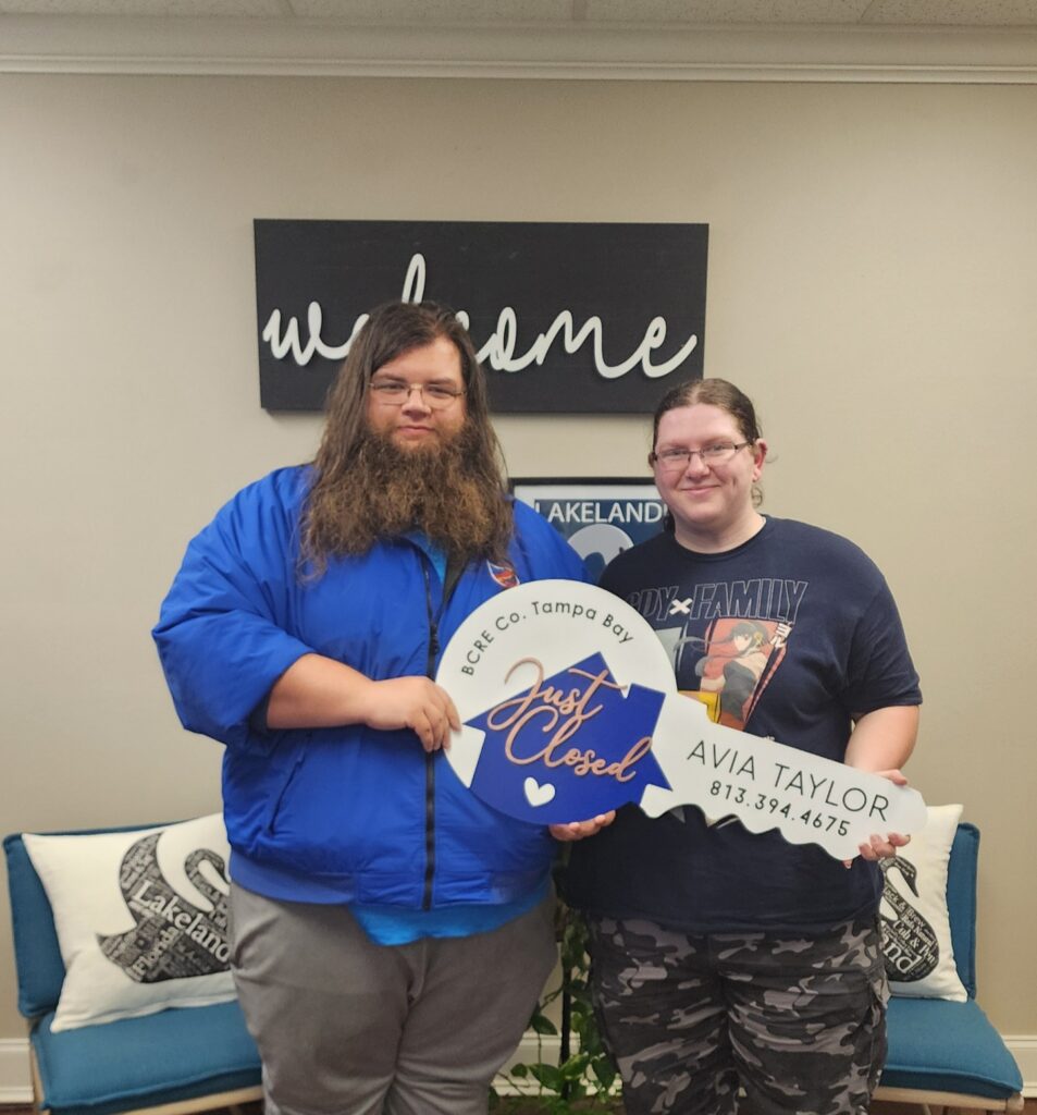 Two people holding up signs in a room.